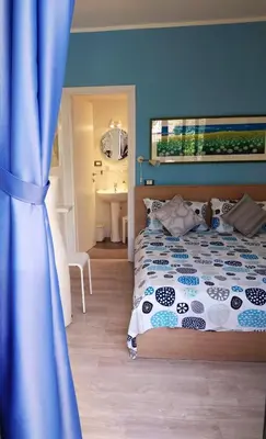 a bedroom with a bed and a blue wall at Il Giardino di Laura Private Rooms Mondello in Mondello