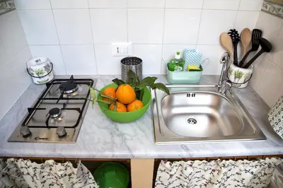 a kitchen counter with a sink and a bowl of oranges at Il Giardino di Laura Private Rooms Mondello in Mondello