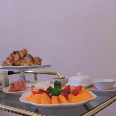 a table with plates of fruit and pastries on it at Il Rosone Luxury B&B in Palermo