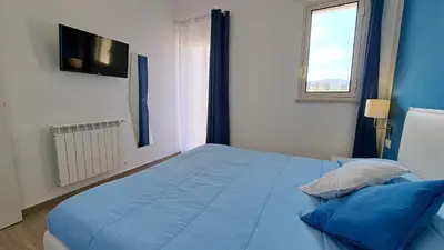 a bedroom with a blue bed and a window at Le Due Sicilie B&B in Lascari