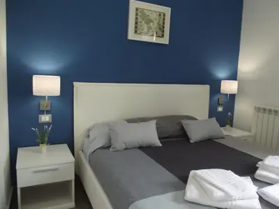a bedroom with a blue wall with a bed and a table at Le Due Sicilie B&B in Lascari