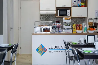 a kitchen with a counter with tables and chairs at Le Due Sicilie B&B in Lascari