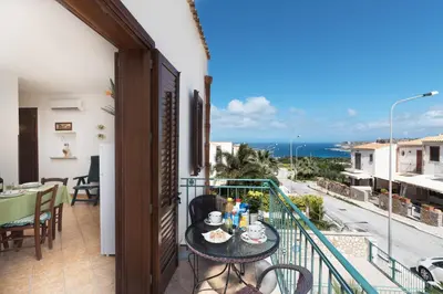 a balcony with a table and a view of the ocean at Appartamenti Irene in Macari