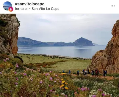 a group of people walking on a trail near a body of water at Appartamenti Irene in Macari