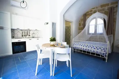 a kitchen with a table and chairs in a room at Sciabika Home - Edificio Egadi in Castellammare del Golfo