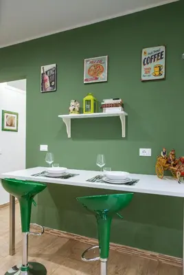 a green room with a counter with two green stools at Il Tempo Ritrovato - Locazione ad uso turistico in Palermo