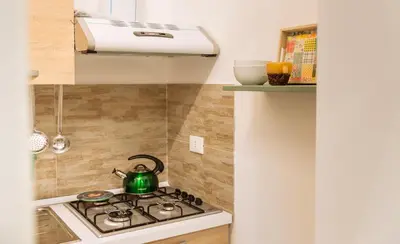 a kitchen with a stove with a green tea kettle at Il Tempo Ritrovato - Locazione ad uso turistico in Palermo