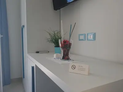 a white counter with a vase with a plant on it at B&B Aloe Comfort Rooms in San Vito lo Capo