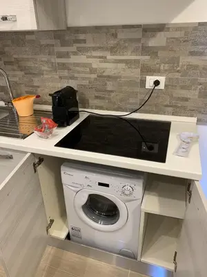 a washing machine under a counter in a kitchen at Le Torri dell'acqua in Palermo