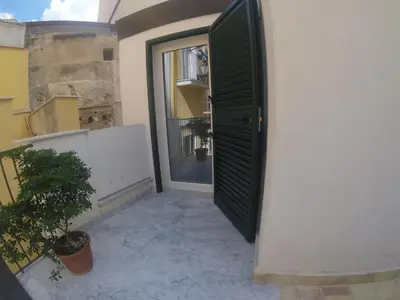 an open door to a balcony with a plant at Kurò in Palermo