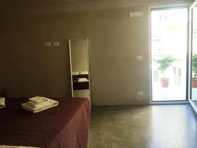 a bedroom with a bed and a sliding glass door at Kurò in Palermo