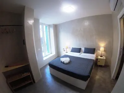 a bedroom with a bed with blue and white sheets at Kurò in Palermo