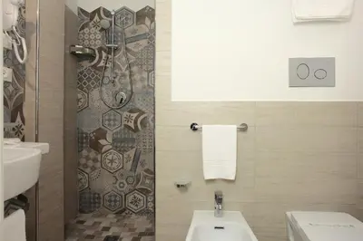 a bathroom with a shower and a toilet and a sink at La Nicchia Smart in San Vito lo Capo