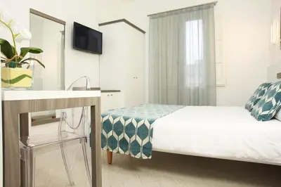 a bedroom with a bed and a sink and a mirror at La Nicchia Smart in San Vito lo Capo