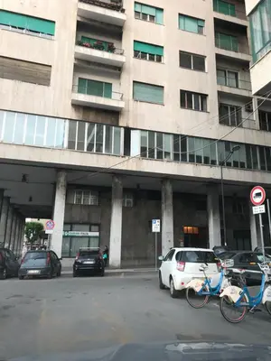 a building with cars and bikes parked in front of it at B&B Questa casa non e'un albergo in Palermo