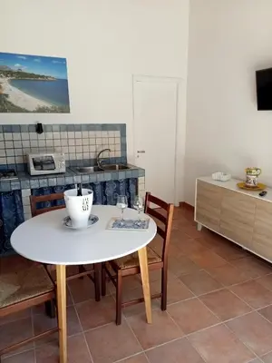 a kitchen with a white table and chairs in a kitchen at Scopelos in Scopello