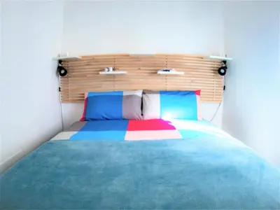 a bedroom with a colorful bed with a wooden headboard at Be Central Rooms in Palermo