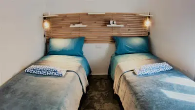 two beds in a small room with blue pillows at Be Central Rooms in Palermo