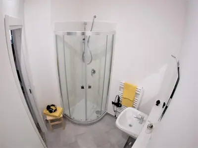 a white bathroom with a shower and a sink at Be Central Rooms in Palermo