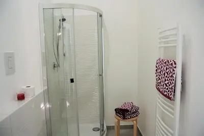 a glass shower in a bathroom with a stool at Be Central Rooms in Palermo