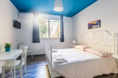 a bedroom with a white bed and a table at B&B Medusa in Santa Flavia