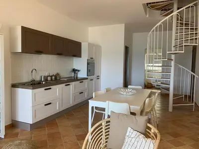 a kitchen with a table and a dining room at Sfondo Blu Villa sul mare in Trabia