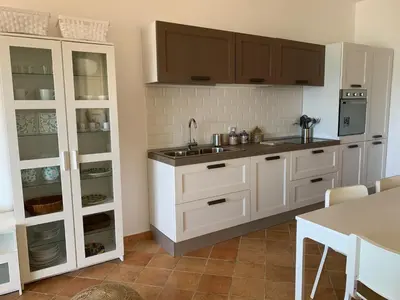 a kitchen with white cabinets and a sink at Sfondo Blu Villa sul mare in Trabia