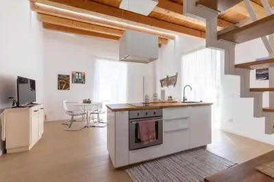 a kitchen with white cabinets and a sink and a table at Il Sonno dei Giusti Apartment by DomuSicily in Palermo