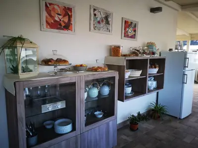 a kitchen with a cabinet with dishes and a sink at B&B Vivere San Vito Lo Capo in San Vito lo Capo