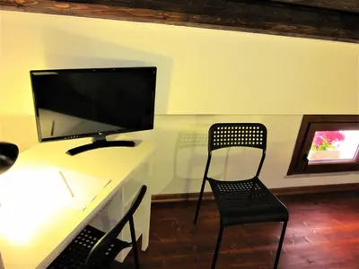 a desk with a computer monitor and a chair at icalderai in Palermo
