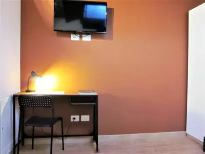 a desk with a chair and a television on a wall at icalderai in Palermo