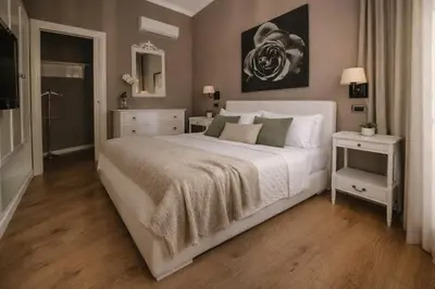 a bedroom with a large white bed and a mirror at Maxim in Palermo