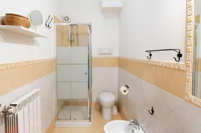 a bathroom with a shower and a toilet and a sink at Khalisa Home in Palermo
