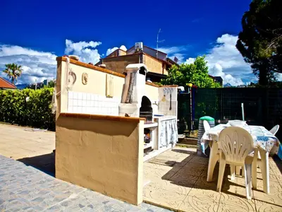 a backyard with a kitchen and a table and chairs at Acasaammari in Campofelice di Roccella