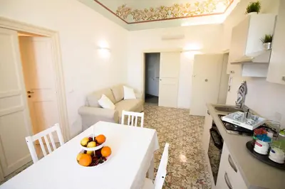 a kitchen and living room with a white table and chairs at Pandora in Porticello