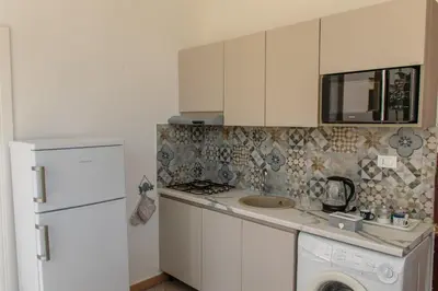 a kitchen with a sink and a white refrigerator at MarieRose House Sferracavallo in Sferracavallo