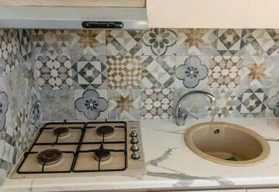 a kitchen counter with a stove and a sink at MarieRose House Sferracavallo in Sferracavallo
