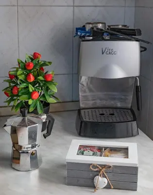 a coffee maker and a vase with a flower at MarieRose House Sferracavallo in Sferracavallo