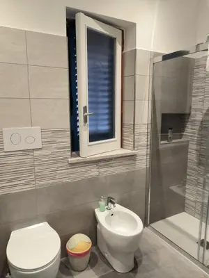 a bathroom with a toilet and a sink and a window at MarieRose House Sferracavallo in Sferracavallo