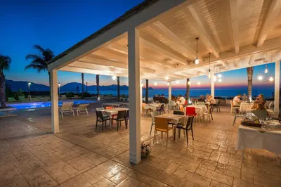 a restaurant with tables and chairs on a patio at Petruso Resort e SPA in Balestrate