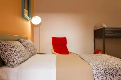 a bedroom with a bed and a red chair at dallo Zio Totò in Palermo