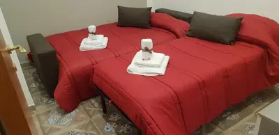 a red bed with two towels on top of it at Casa Baarìa in Bagheria