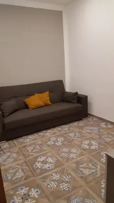a living room with a couch and a tile floor at Casa Baarìa in Bagheria