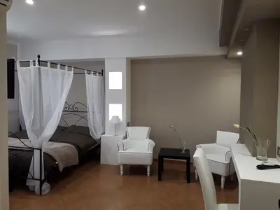 a bedroom with a bed and two chairs and a table at Rocca Di Monreale in Monreale