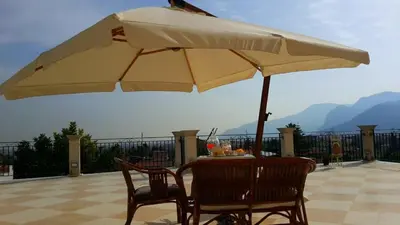 a table and chairs with a large umbrella at Rocca Di Monreale in Monreale