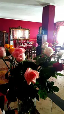 a vase of roses in a room with a table at Rocca Di Monreale in Monreale