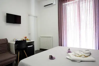 a hotel room with a bed and a chair and a window at Amuri Room&Suite in Palermo