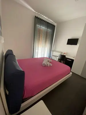 a bedroom with a large bed with a pink blanket at Amuri Room&Suite in Palermo