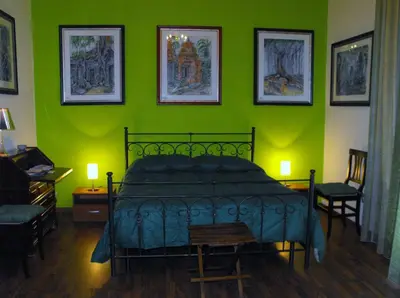 a bedroom with a bed and a green wall at B&B Casa Degli Artisti in Palermo