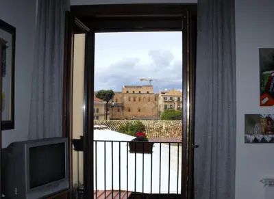 a door to a balcony with a view of a building at B&B Casa Degli Artisti in Palermo